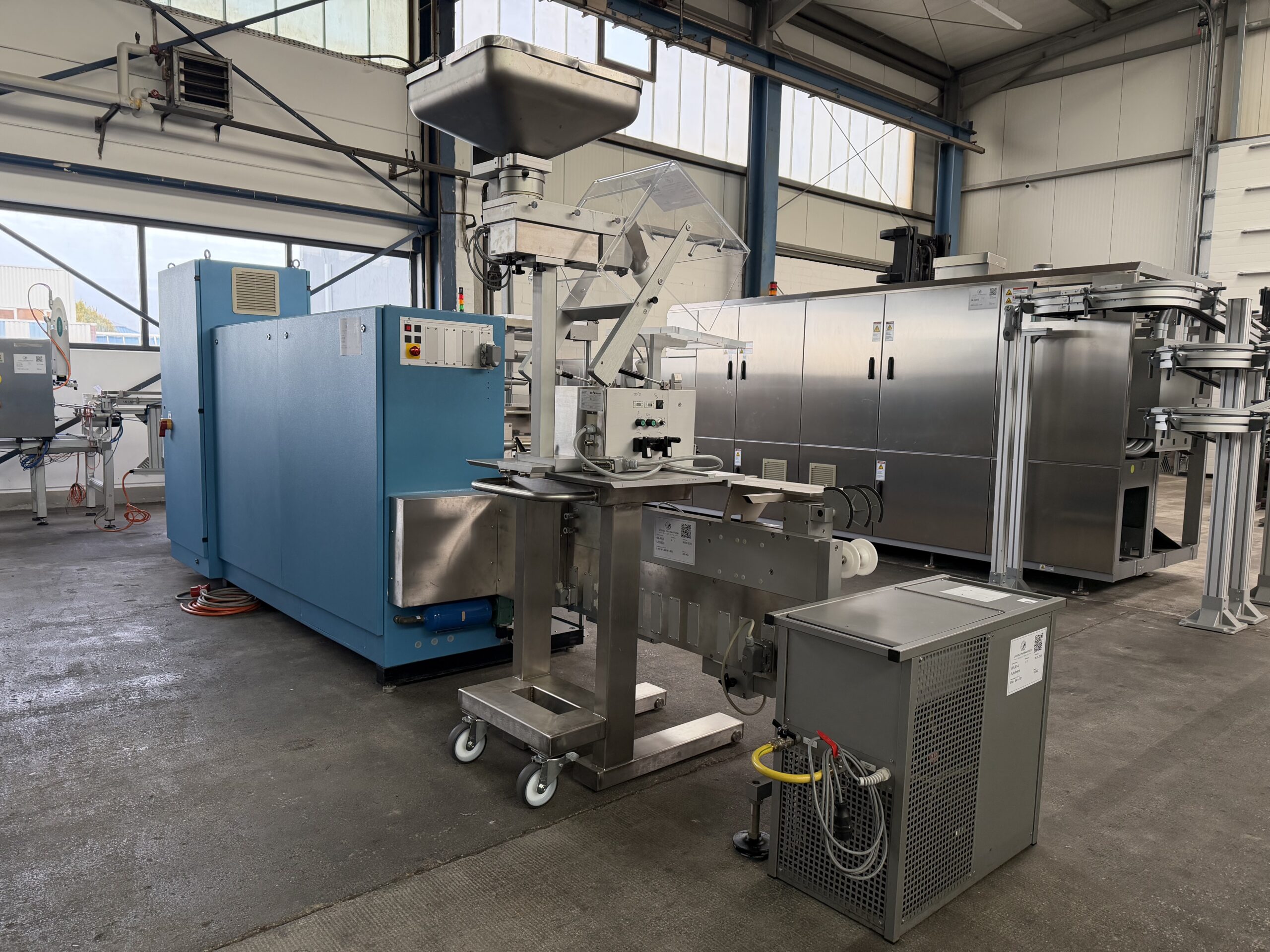 Uhlmann UPS 300 Blistermaschine mit Produkttrichter und Zuführeinheit in seitlicher Ansicht
